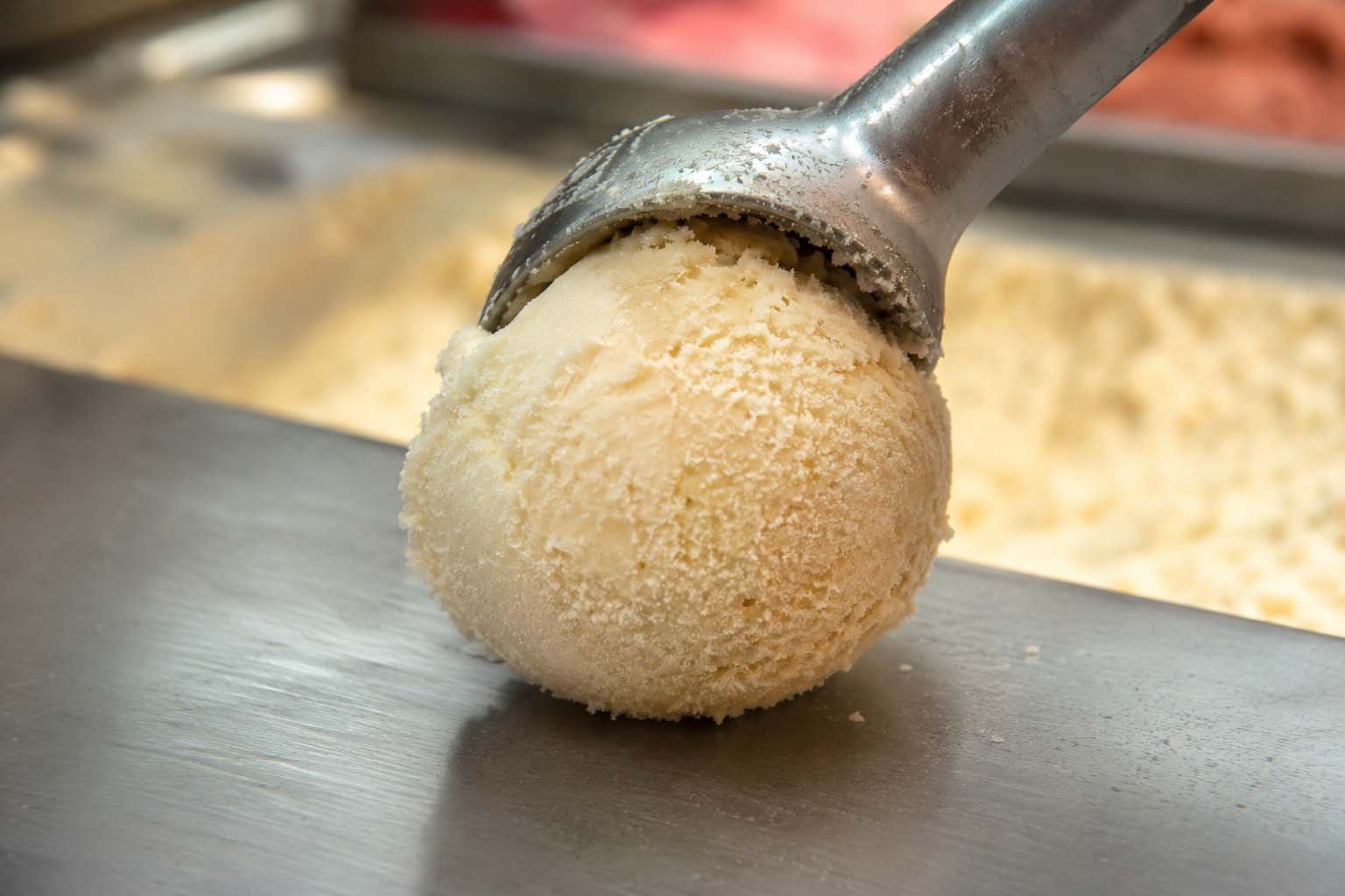 Bola de sorvete artesanal dura e com cristais de gelo visíveis, recém-tirada do freezer